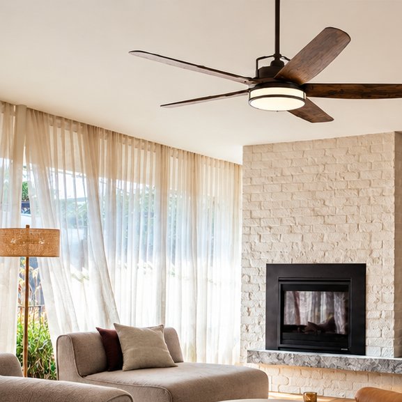 Dark ceiling fan with walnut-look blades and a light ring in a living room with sheer curtains and a stone fireplace
