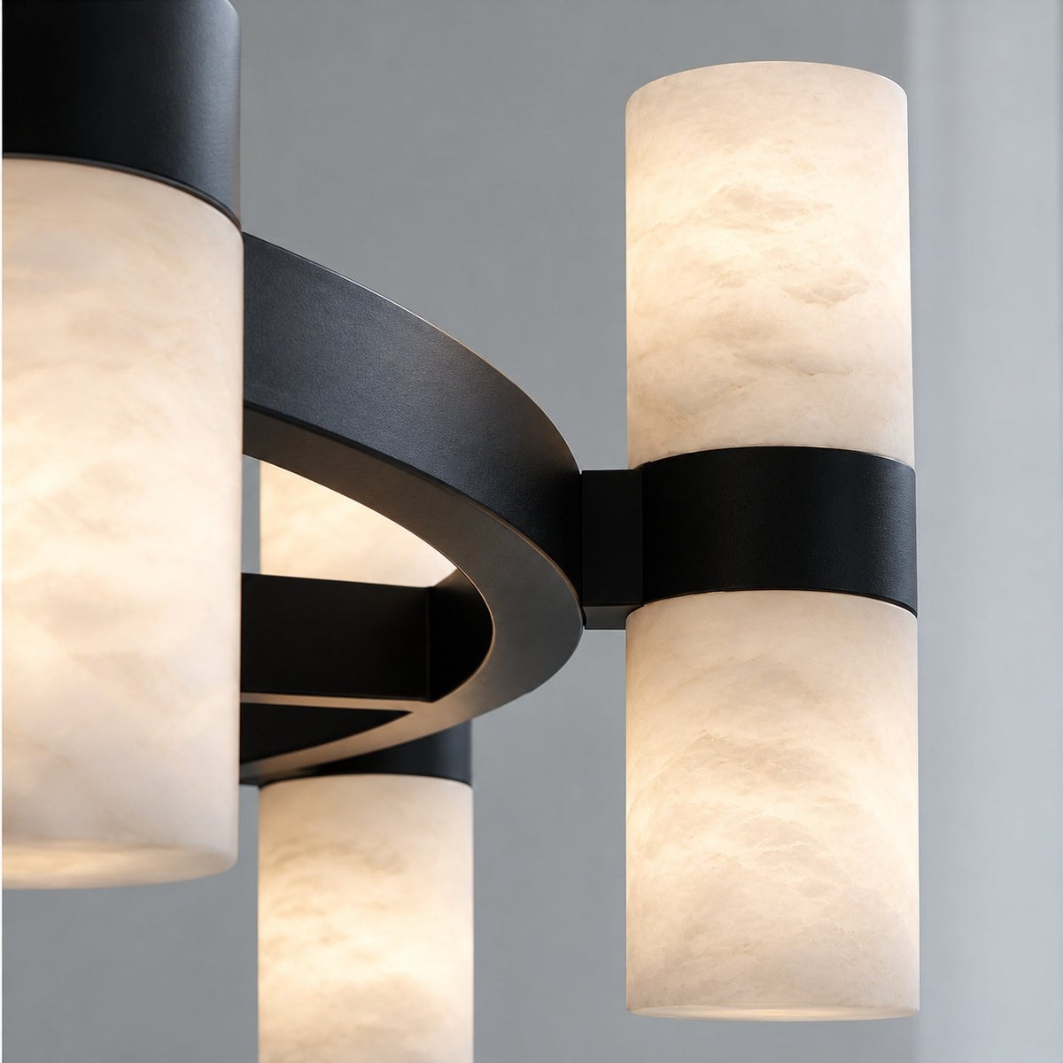 Close view of a black ring chandelier with alabaster cylinder lights